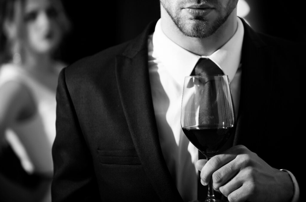 ポートを飲む紳士と、それを背後から見つめる女性